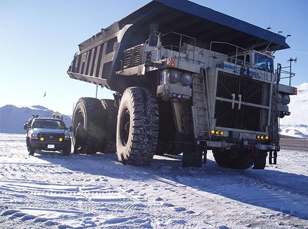 Mobile mechanic servicing mining hauler in the snow