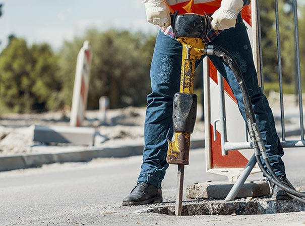 Municipal worker using air powered jackhammer