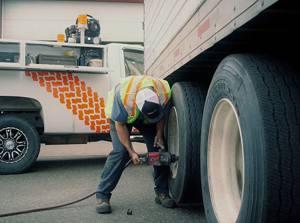 Worker services large vehicle in transportation industry