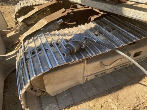 Air tool rests on metal excavator track