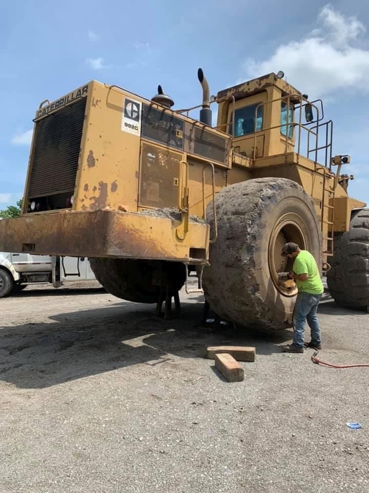 Operator performs tire service on Caterpillar 992C machine