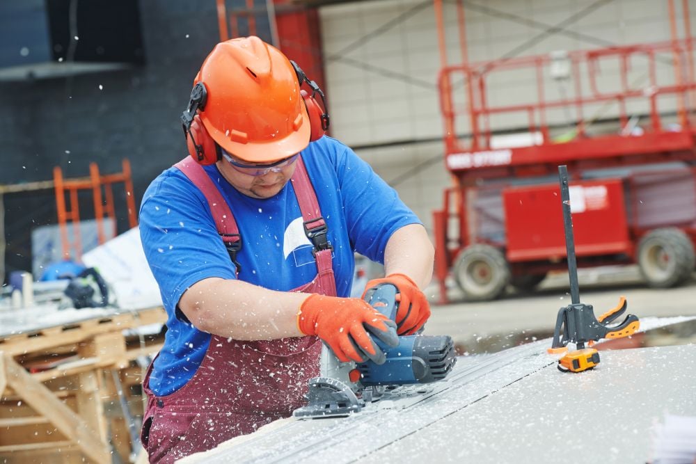 Construction worker using circular power saw