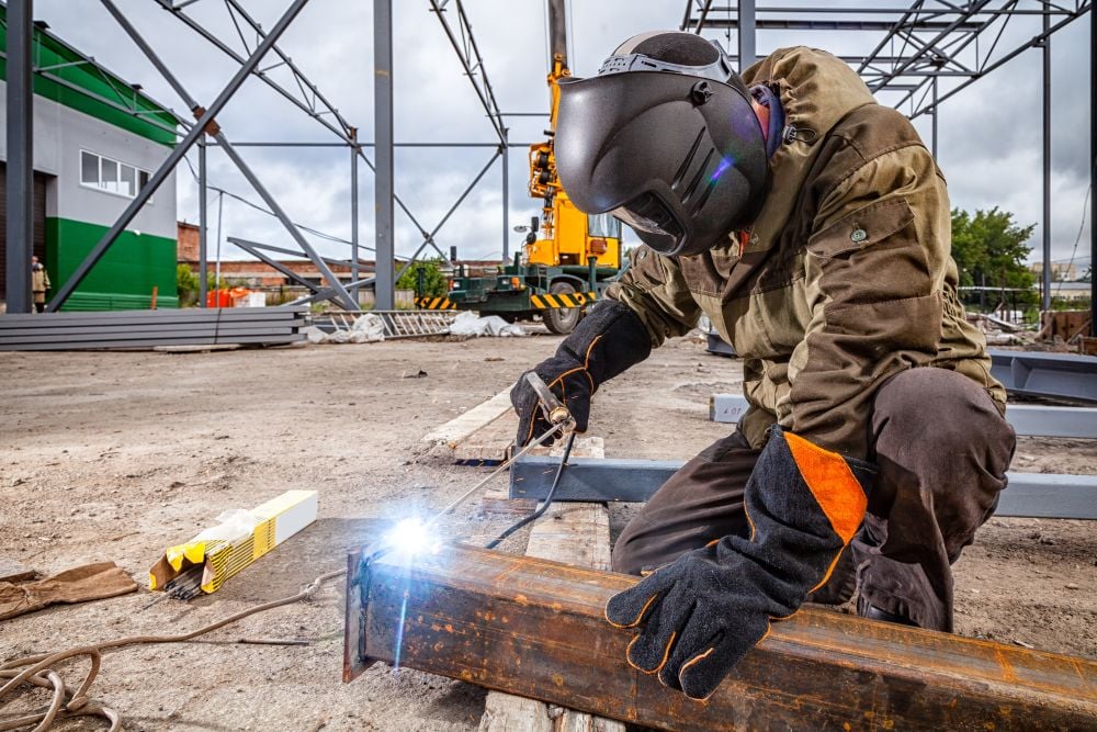 Welder works outside welding rebar