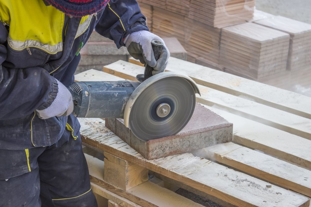 A grinder cuts paving stones at a construction site
